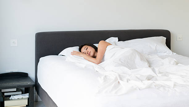 Beautiful young asian woman sleeping in bed at home